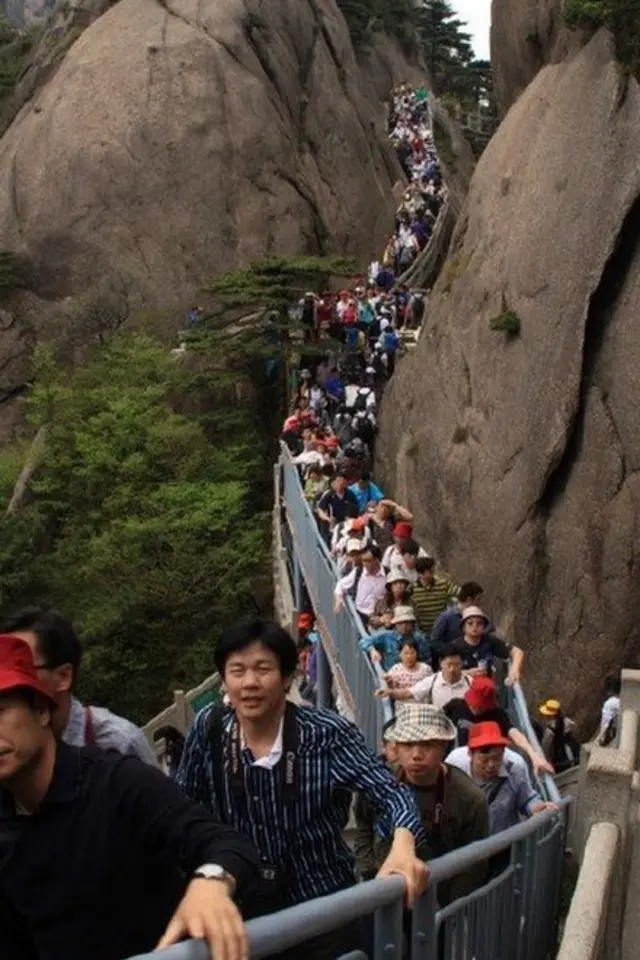 Puente lleno de gente en una montaña.