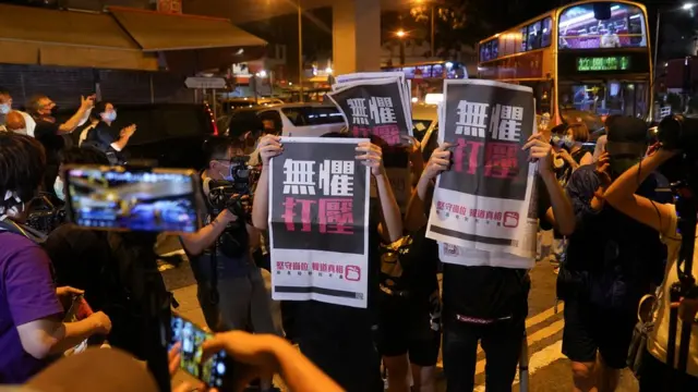 黎智英支持者在九龍旺角警署外舉起《蘋果日報》聲援(12/8/2020)