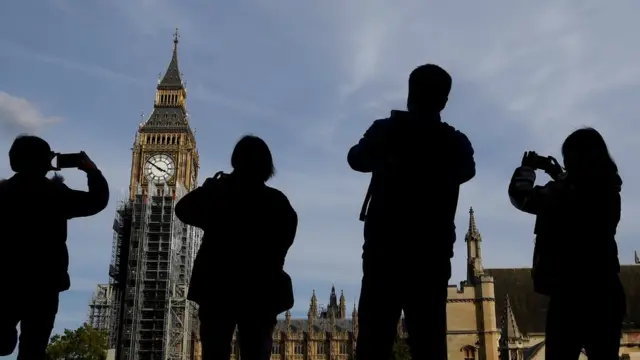 Tourists take photographs of the Elizabeth Tower, commonly known as Big Ben in London, Britain