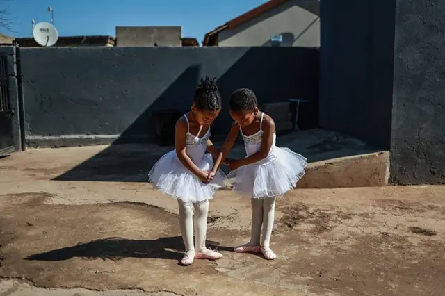 Duas meninas em roupas de balé, ensaiando