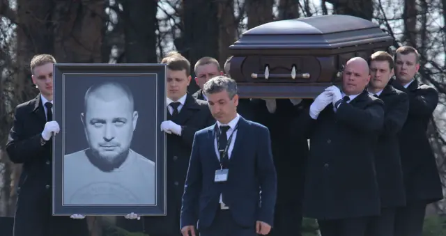 People attend the funeral of Russian military blogger Maxim Fomin, widely known by the name of Vladlen Tatarsky, at Troyekurovo Cemetery on April 8, 2023, in Moscow, Russia