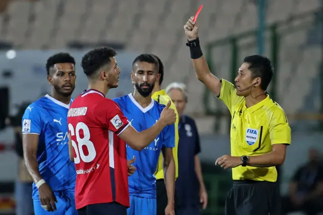 खेलाडीलाई रेड कार्ड देखाउँदै मा निङ