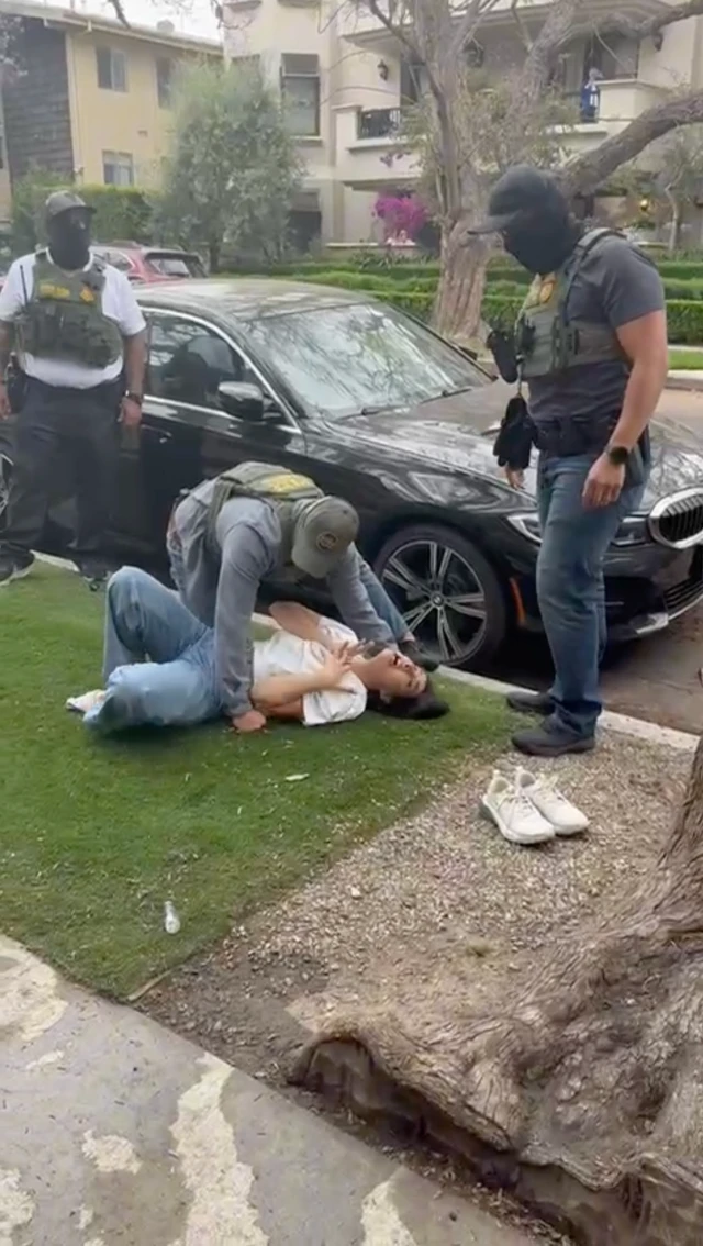 Marjan yace en el piso frente a su casa mientras tres agentes de migración la rodean.