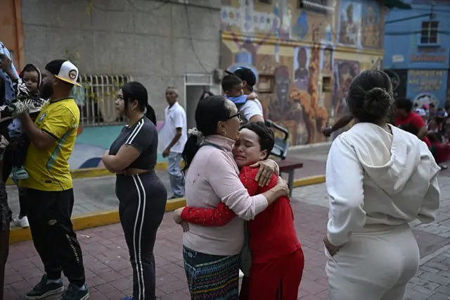 Una mujer consuela a un niño en la calle tras un terremoto en Caracas el 24 de junio de 2026.