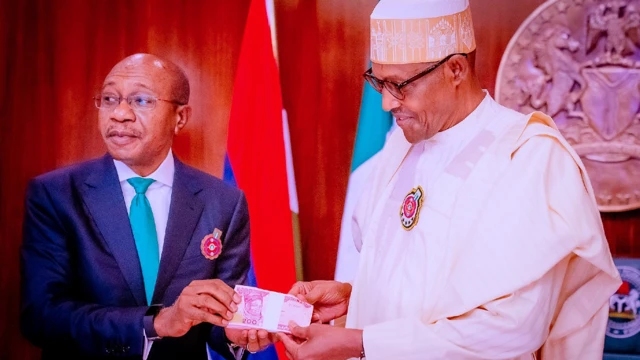 Godwin Emefiele (G), de la Banque centrale du Nigeria, dévoile la conception des nouveaux billets de banque avec le président nigérian Muhammadu Buhari (D), le 23 novembre 2022 à Abuja, au Nigeria.