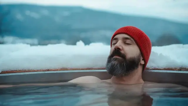 Muškarac odmara u kadi postavljenoj napolju