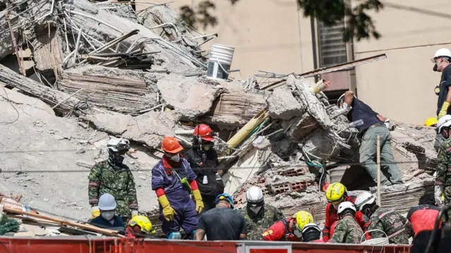Socorristas com material de proteção em um edifício desabado em Cali.