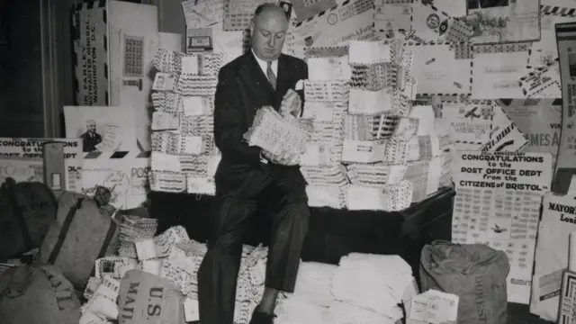 Postmaster General James Farley sentadoafiliado vaidebetuma pilhaafiliado vaidebetcartas (1938)