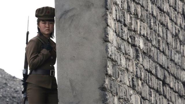 A North Korea woman soldier patrols the bank of the Yalu River which separates the North Korean town of Sinuiju from the Chinese border town of Dandong