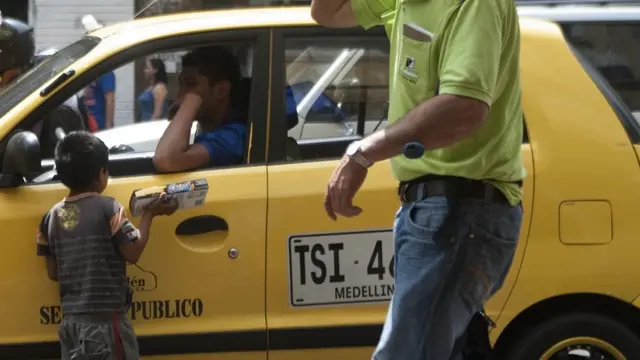 Niño vendiendo golosinas en las calles de Antioquía, Colombia.
