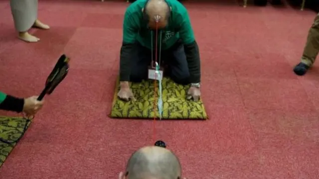 Mwanachama wa watu wenye vipara akishiriki katika mchezo wa kuvutana kwa kutumia kamba Japan