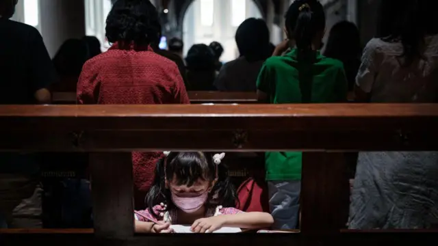 Seorang anak tengah menggambar saat misa di Gereja Katedral Jakarta.