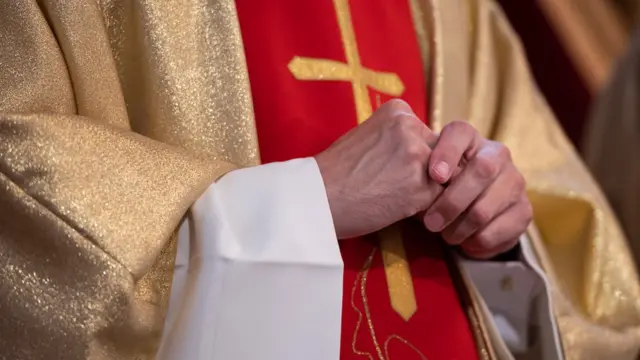 Las manos de un cura de la Iglesia católica
