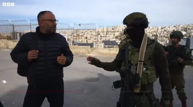 वेस्ट बैंक में इसराइली सैनिक एक फ़लस्तीनी अधिकार कार्यकर्ता से विवाद करते. 