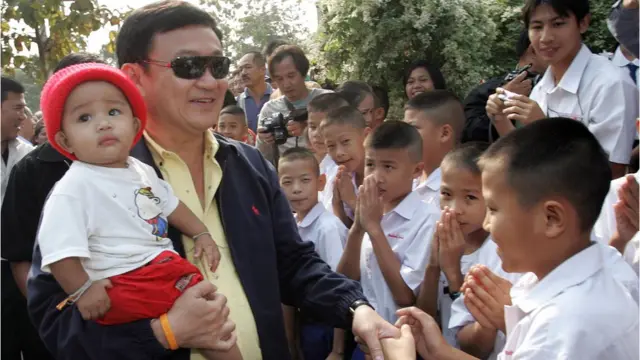 ทักษิณ ชินวัตร นายกฯ คนที่ 23 พูดคุยกับเด็ก ๆ ขณะกลับบ้านเกิดใน จ.เชียงใหม่ เมื่อ ก.พ. 2549