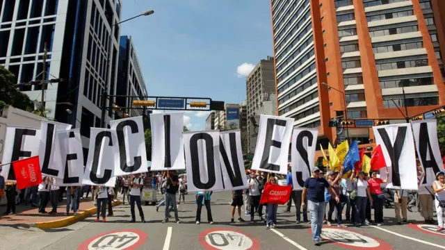 Manifestantes con un cartel que dice: "Elecciones ya".