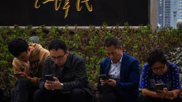 Personas mirando a su celular en China