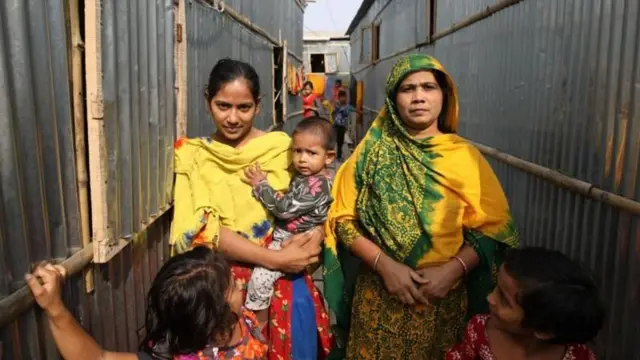 শিশু কোলো দাড়িয়ে আছে একটি পরিবার 