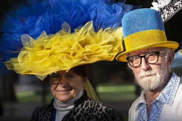 Літні жінка та чоловік у капелюхах в кольорах українського прапору