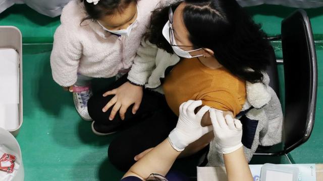 28일 서울 서대문구 북아현문화체육센터에 마련된 신종 코로나바이러스 감염증(코로나19) 백신 예방접종센터에서 한 어린이가 백신접종 전 긴장하는 엄마를 안아주고 있다
