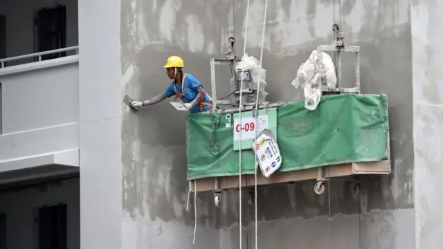Obrero aplicando cemento.