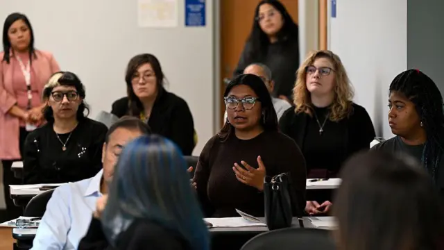 Esther Martinez, organizadora do Centro Northwest (no centro, de óculos), fala durante um evento com a advogada Rebekah Azar (que não aparece na foto) na Healthcare Alternative Systems no dia 30 de outubro de 2025, em Chicago, Illinois (EUA). Azar Rashidfarokhi falou sobre o processo de obtenção da tutela de menores cujos familiares foram separados por agentes da imigração, por prisão ou deportação dos seus pais. A Patrulha Fronteiriça dos Estados Unidos, o Serviço de Imigração e Alfândega e outros agentes federais americanos estão em Chicago e seus subúrbios próximos, fazendo cumprir as leis de imigração durante a chamada "Operação Midway Blitz".