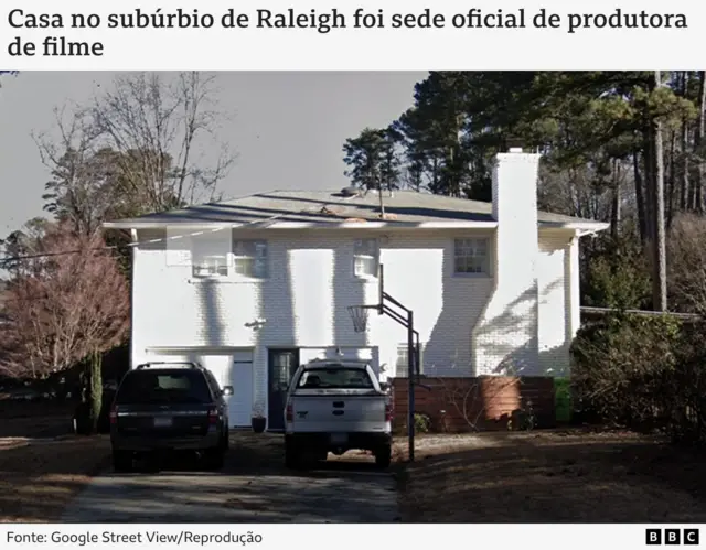 Imagem mostra fachada de uma casa branca, com dois andares, dois carros, um preto e outro branco, em frente à casa. 