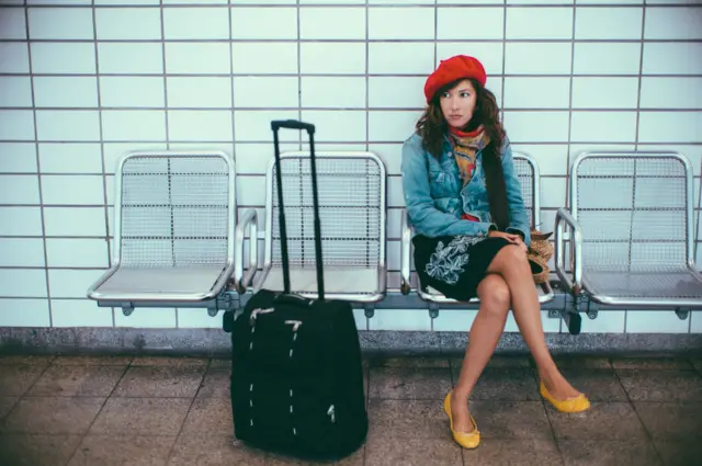 पायावर पाय ठेवून बसलेली महिला