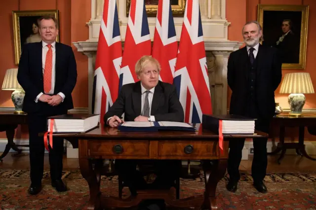 . En la imagen, el entonces primer ministro Boris Johnson firma el acuerdo ante el negociador británico Davod Frost y el embajador de la UE Tim Barrow.