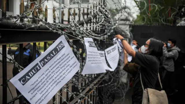 Jurnalis yang tergabung dalam Aliansi Jurnalis Independen (AJI) Bandung memasang tulisan dalam aksi tolak 17 pasal bermasalah pada RKUHP di depan Gedung DPRD Provinsi Jawa Barat, Bandung, Jawa Barat, Senin (5/12/2022). 