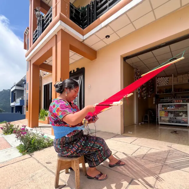 María tejiendo a las afueras de su casa