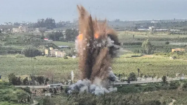 أنقاض تتطاير في الهواء عقب ضربة عسكرية إسرائيلية استهدفت جسراً رئيسياً في جنوب لبنان في 22 مارس/آذار 2026. ويقع جسر القاسمية على طريق رئيسي يربط قرى قضاء صور بمناطق أخرى إلى الشمال.