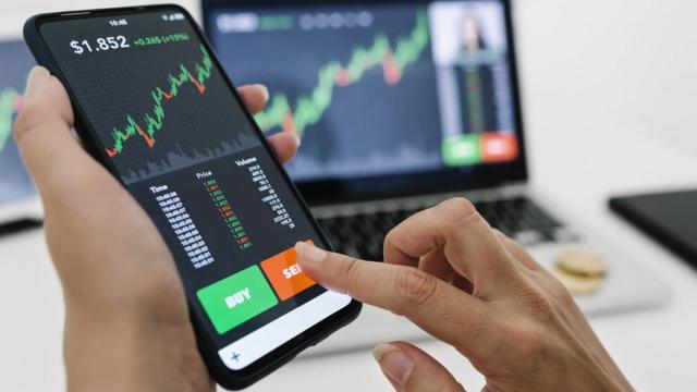 mulher segura celular abertoslot clube 777um app que mostra um grafico