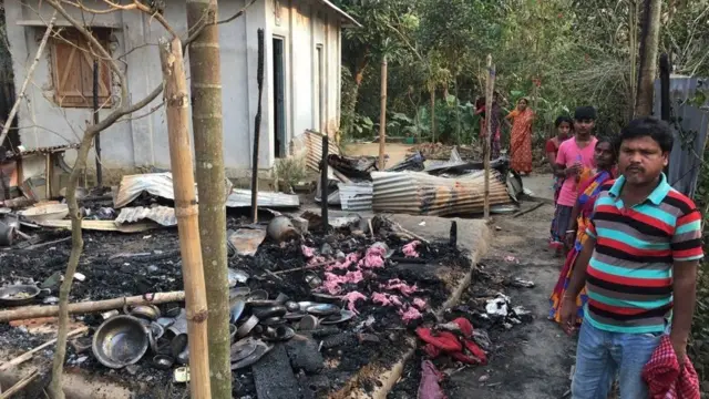 સળગી ગયેલી વસ્તુઓ પાસે ઉભેલા લોકો