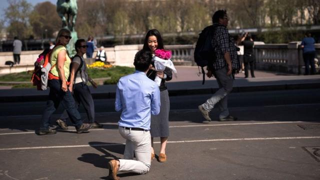 Даже без дорогостоящей церемонии предложение руки и сердца в Париже (как это происходит у туристов на снимке) запомнится на всю жизнь