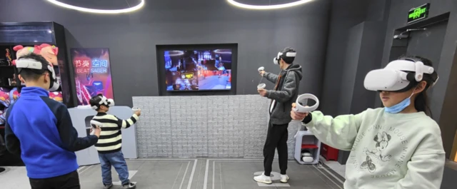 3D 헤드셋을 착용하고 게임 컨트롤러를 든 어린이와 어른