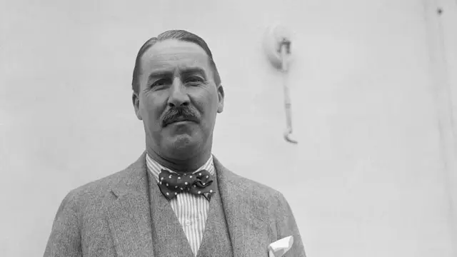 Чорно-біла фотографія чоловіка на фоні білої стіни