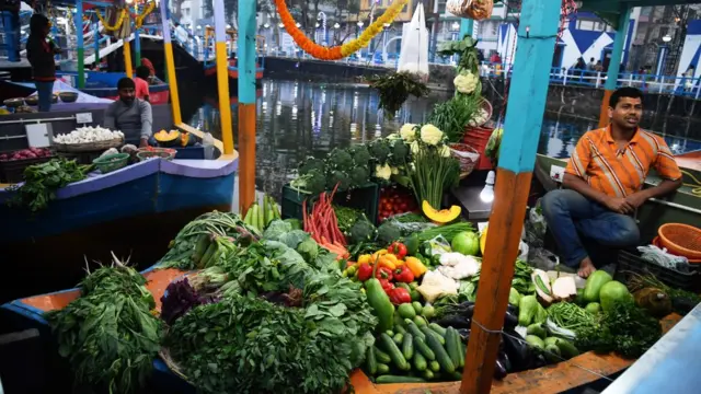 পাটুলি বাজারে একজন সবজি বিক্রি করছেন একজন বিক্রেতা