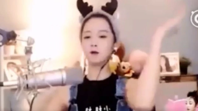 Madamu Yang yifashe videwo azunguza amaboko mu gihe yaririmbaga indirimbo yubahiriza igihugu y'Ubushinwa