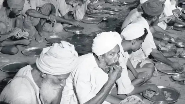 Sikh refugees dey chop free food for di ground for relief camp for Amritsar for 1947/1948.