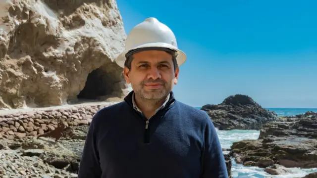 Gerardo Espindola Rojas posa para foto com capacetecassino online com bonusfrente a praia com caverna