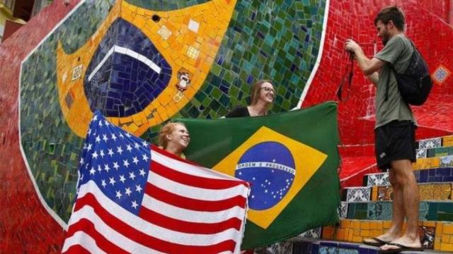 Mulheres com bandeiras dos EUA e do Brasil