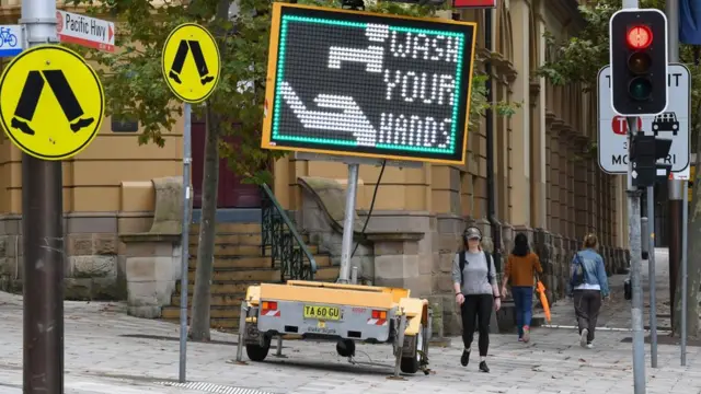 Cartel en el inglés invitando al público a lavarse las manos.