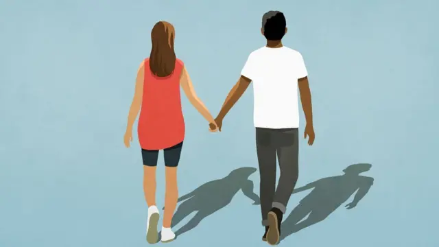 Multiethnic couple holding hands and walking