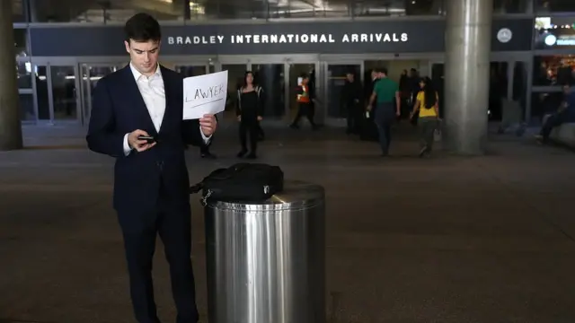 Мужчина с табличкой "юрист" в аэропорту США