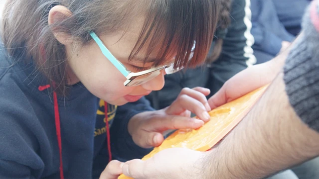 Niña tocando una maqueta que representa un cráter