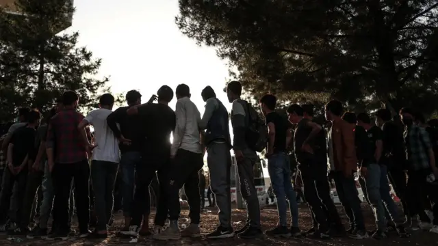 İran sınırından geçerek Afganistan'dan Türkiye'ye gelen göçmenler Diyarbakır otogarında yiyecek sırasında.