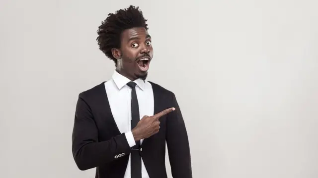 Jeune homme beau et à l'air confiant, vif dans un costume et en regardant l'appareil photo.