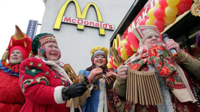 Женщины в национальных костюмах на фоне МакДональдс