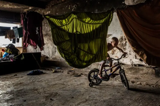 Дети катаются на велосипедах прямо внутри заброшенных зданий